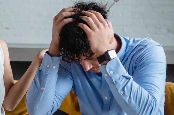 Mann ist überlastet und hält seine Hände an den Kopf