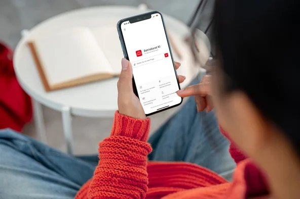 Frau hält Handy mit KI-Tool in der Hand