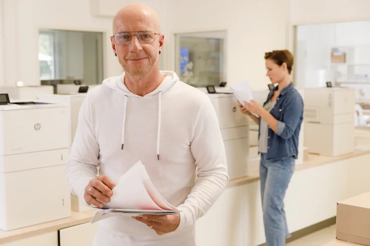 Ein Mann hat gedrucktes Papier in der Hand