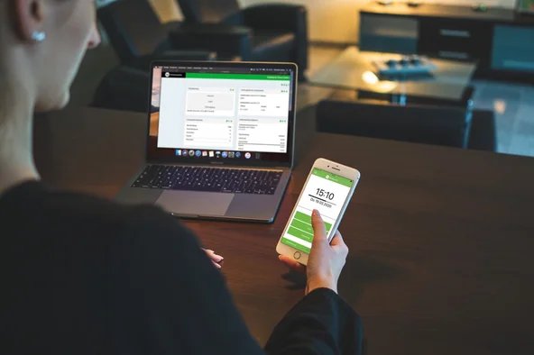 Eine Frau loggt sich am Handy in die Arbeitszeiterfassung ein