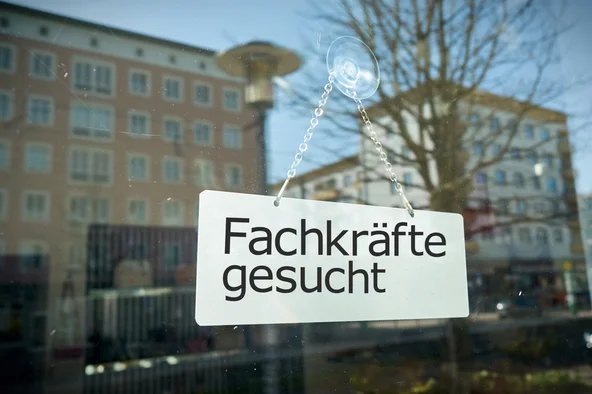 An einem Fenster ein Schild auf dem steht: Fachkräfte gesucht