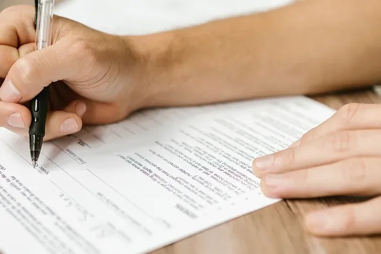 Eine Person unterschreibt die Beschlussfassung des Betriebsrats