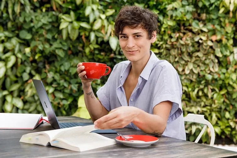 Person sitzt mit ihrem Kaffee draußen